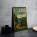 A vintage metal sign for Tolland State Forest in Massachusetts, featuring a scenic illustration of the forest and a path leading to a lake.