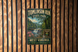 A vintage metal sign for Tomlinson Run State Park in West Virginia, featuring a scenic illustration of the park's waterfall and surrounding forest.
