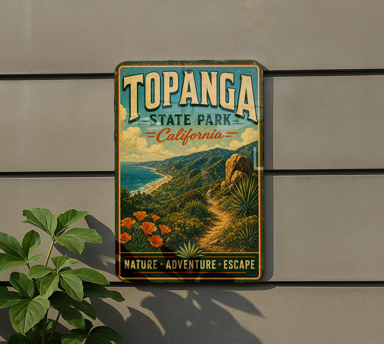 A vintage-style metal sign for Topanga State Park in California, featuring a scenic landscape with mountains, a beach, and a path leading through the vegetation.