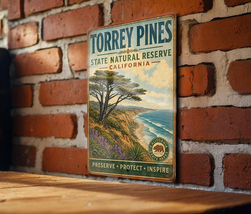 A vintage metal sign for Torrey Pines State Natural Reserve in California, featuring a scenic landscape with a pine tree and ocean.