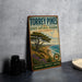A vintage-style metal sign for Torrey Pines State Natural Reserve in California, featuring a scenic landscape with a pine tree and ocean in the background.