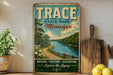 a vintage-style sign for Trace State Park in Mississippi, with a scenic illustration of a river and forest.