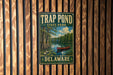 A metal sign for Trap Pond State Park in Delaware, featuring a painting of a red canoe on a lake surrounded by trees.