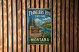 A vintage metal sign for Travelers' Rest State Park in Montana, featuring a scenic landscape with mountains, a river, and pine trees.