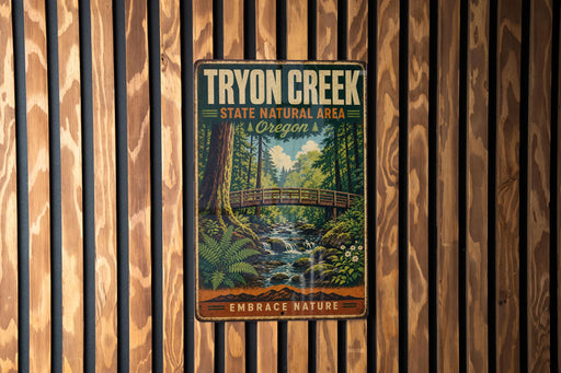 A vintage metal sign for Tryon Creek State Natural Area in Oregon, featuring a scenic illustration of a forest and a bridge.