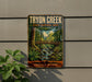 A vintage-style metal sign for "Tryingon Creek State Natural Area" in Oregon, featuring a scenic illustration of a forest and a bridge.