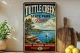 A vintage-style sign for Tuttle Creek State Park in Kansas, featuring a scenic landscape with a lake, mountains, and a sailboat.