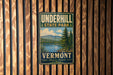 A vintage-style metal sign for Vermont State Park, featuring a scenic landscape with a lake and mountains.