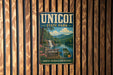 A vintage metal sign for UNICOI State Park, featuring a scenic landscape with a waterfall and mountains, mounted on a wooden wall.