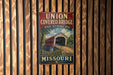 A vintage metal sign for the Union Covered Bridge in Missouri, featuring an illustration of the covered bridge and the state's name.