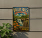 A vintage-style metal sign for Valley Falls State Park in West Virginia, featuring a waterfall and lush greenery.