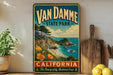 A vintage-style sign for Van Damme State Park in California, featuring a scenic coastal landscape with a waterfall and beach.