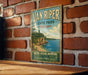 A vintage-style metal sign for Van Riper State Park in Michigan, featuring a scenic landscape with a lake and mountains.