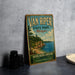 A vintage-style sign for Van Riper State Park in Michigan, featuring a scenic landscape with a lake and forest.