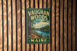 A vintage metal sign for Vaughan Woods State Park in Maine, featuring a scenic landscape with a river and pine trees.