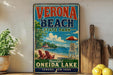 A vintage-style sign for Verona Beach State Park, featuring a beach scene with a lifeguard tower, chairs, and an umbrella.