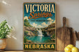 A vintage-style sign for Victoria Springs, a state recreation area in Nebraska, featuring a scenic image of a waterfall and lush greenery.