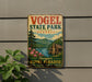 A vintage-style metal sign for Vogel State Park in Georgia, featuring a scenic mountain landscape with a cabin and flowers.