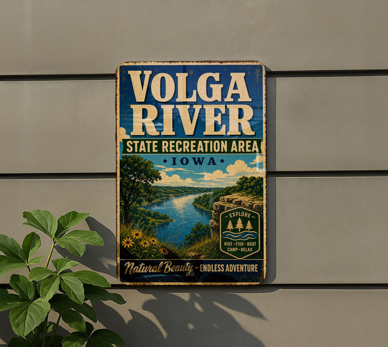 A vintage-style sign for the Volga River State Recreation Area in Iowa, featuring a scenic landscape with a river, mountains, and a bridge.