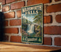 A vintage metal sign for Wadsworth Falls State Park in Connecticut, featuring a scenic image of the waterfall surrounded by lush greenery.