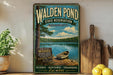 A vintage-style metal sign for Walden Pond, featuring a scenic image of a lake surrounded by woods and a boat, with text promoting the state reserve and its scenic, historic, and tranquil aspects.