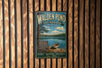 A vintage metal sign for Walden Pond, a state reserve in Massachusetts, featuring a scenic image of a lake with a boat and surrounded by woods.