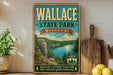 A vintage-style metal sign for Wallace State Park in Missouri, featuring a scenic landscape with a lake and mountains.
