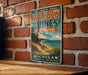 A vintage-style metal sign for Warren Dunes State Park in Michigan, featuring a scenic beach landscape with a path leading to the beach.
