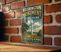A vintage metal sign displaying the Washington Monument and State Park in Maryland, with a scenic illustration of the monument and surrounding landscape.