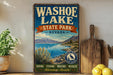A vintage-style metal sign for Washoe Lake State Park, Nevada, featuring a scenic landscape with mountains, a lake, and a bird in flight.