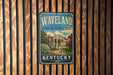 A vintage-style metal sign for the state historic site of Kentucky, featuring a building and trees, mounted on a wooden wall.