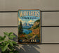 A vintage-style metal sign for Wayfarers State Park in Montana, featuring a scenic mountain landscape with a lake and pine trees.