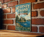 A vintage-style metal sign for Wellesley Island State Park in New York, featuring a scenic image of the park and a castle.
