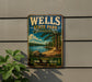 A vintage metal sign for Wells State Park in Massachusetts, featuring a scenic landscape with a lake, trees, and mountains.