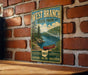 A vintage-style metal sign for West Branch State Park, featuring a scenic illustration of a lake and forest, mounted on a brick wall.
