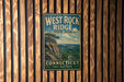 A vintage metal sign for West Rock Ridge State Park in Connecticut, featuring a scenic landscape with a cliff and trees.