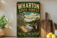 A vintage-style metal sign for Wharton State Forest, featuring a scenic landscape with a river, pine trees, and a sign indicating the location as New Jersey.