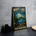 A vintage-style metal sign for White Lake State Park in New Hampshire, featuring a scenic landscape with a lake, mountains, pine trees, and a sailboat.