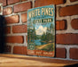 A vintage-style metal sign for White Pines State Park in Illinois, featuring a scenic illustration of pine trees and a lake.