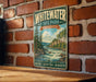 A vintage-style metal sign for Whitewater State Park in Minnesota, featuring a scenic landscape with a river, mountains, and pine trees.