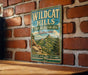 A vintage-style metal sign for Wildcat Hills, a state recreation area in Nebraska, is displayed on a brick wall.