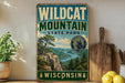 A vintage-style metal sign for Wildcat Mountain State Park in Wisconsin, featuring a scenic landscape with a mountain, river, and pine trees.