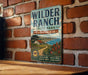 A vintage metal sign for Wilder Ranch State Park in California, featuring a scenic illustration of the park's landscape.