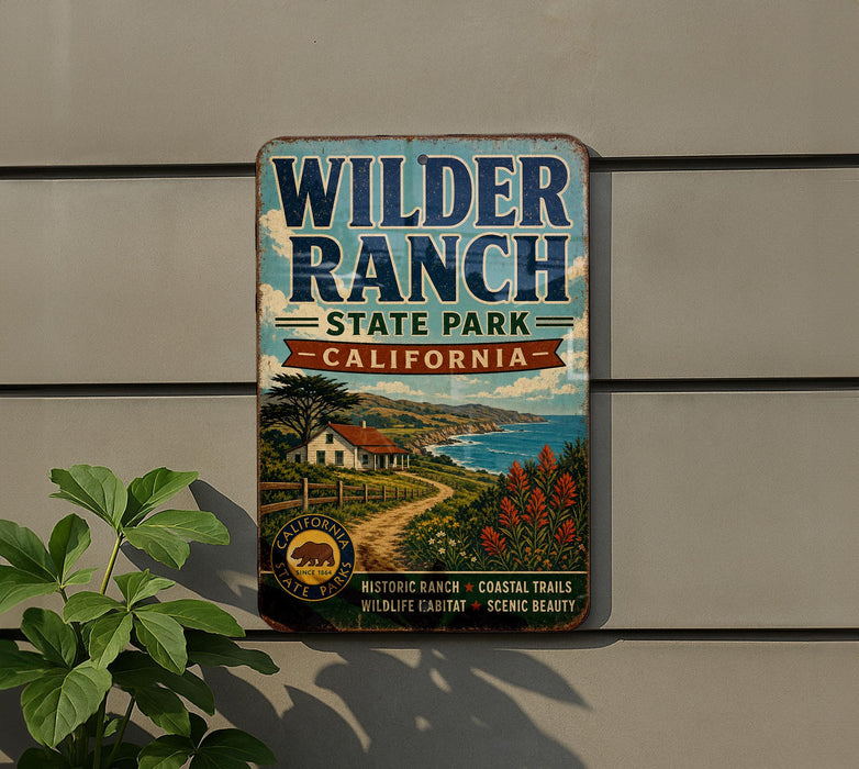 A vintage metal sign for Wilder Ranch State Park in California, featuring a scenic landscape with a house, trees, and a winding path.