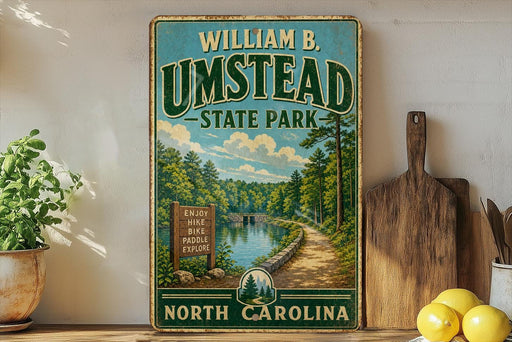 A vintage-style poster advertising William B. Umstead State Park in North Carolina, featuring a scenic landscape with a lake and forest.