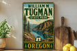 A vintage-style metal sign for William M. Tugman State Park in Oregon, featuring a scenic mountain landscape with a river.