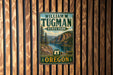 A vintage metal sign for William M. Tugman State Park in Oregon, featuring a scenic mountain landscape.