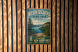 A vintage metal sign for Wilson-Tuscarora State Park in New York, featuring a scenic landscape with a lake and mountains.