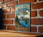 A vintage-style metal sign for Winchester Lake State Park in Idaho, featuring a scenic landscape with mountains, trees, and a lake.