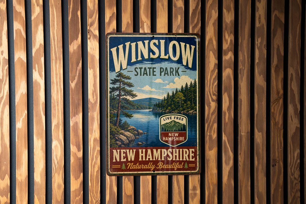 A vintage metal sign for Winslow State Park in New Hampshire, featuring a scenic landscape with a lake and pine trees.